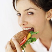 portrait of a woman eating a salad bag